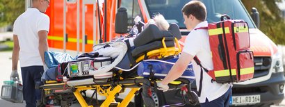 A patient is lying on the stretcher and is being ventilated