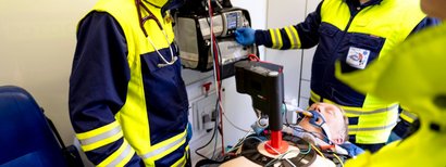 Rescue workers provide care for an unconscious person in an ambulance using ventilators and resuscitation equipment.