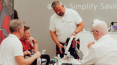An employee demonstrates the use of a medical device to participants in a training situation.
