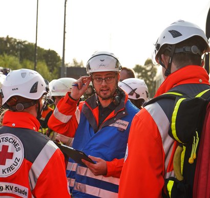 A paramedic with a clipboard in his hand gives instructions.